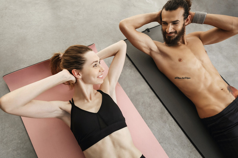 A man and a woman doing abs